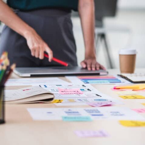 UX developer and ui designed brainstorm about mobile app interface with color code and sticky notes laid out on the table