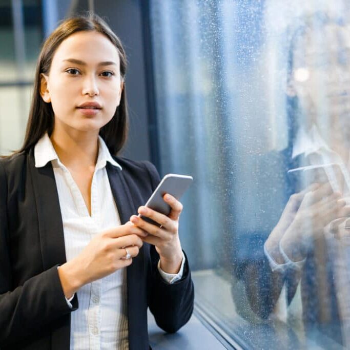 Businesswoman on smartphone thinking about career change